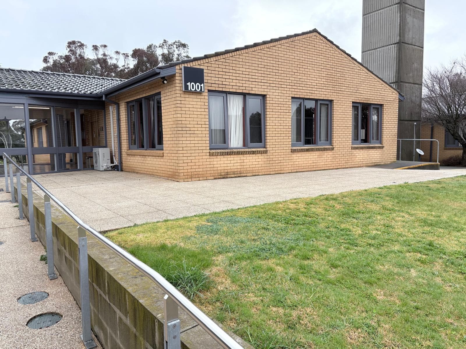 Cream brick campus building with freshly painted charcoal gutters, fascias and window frames, Orange NSW