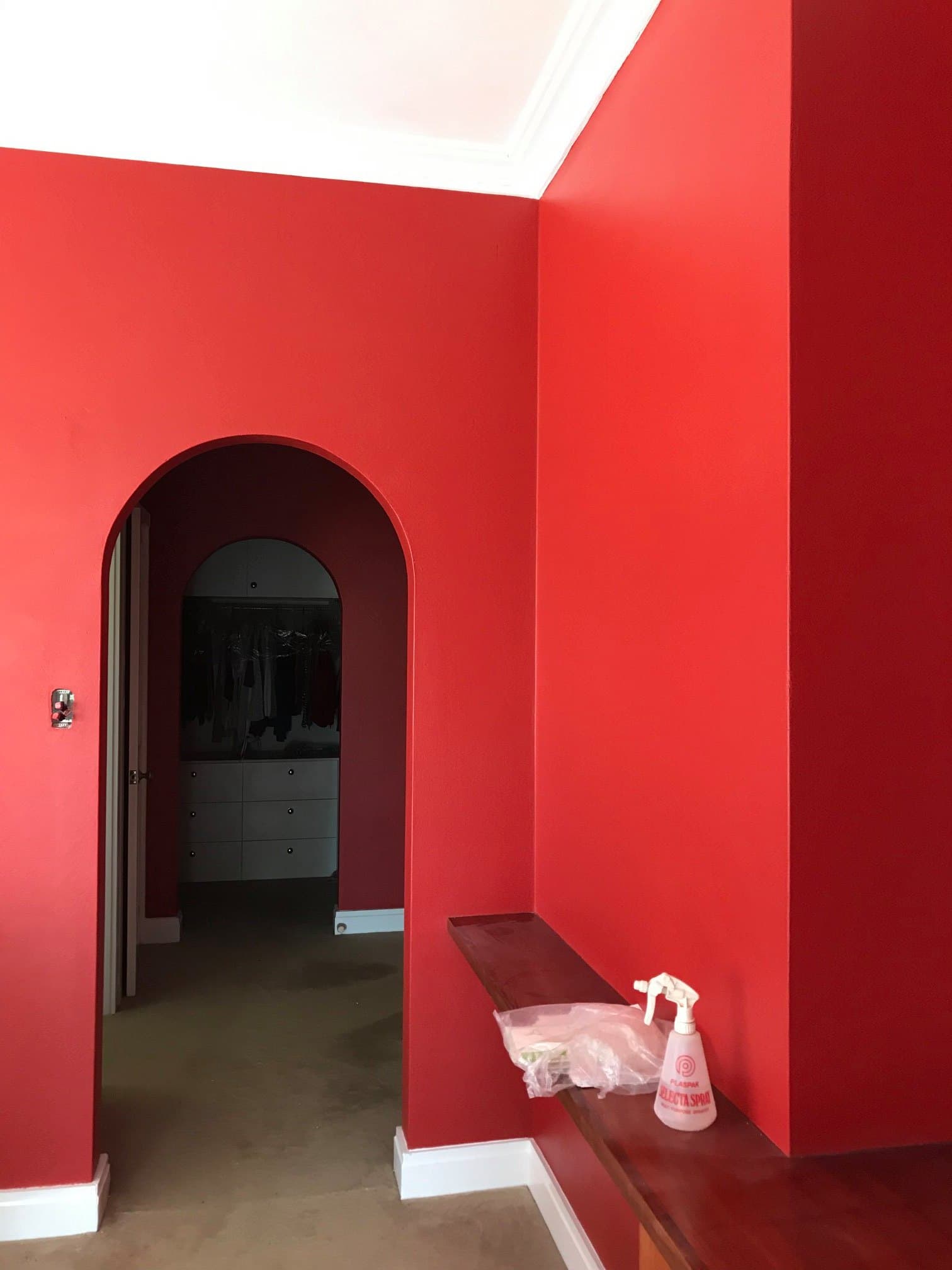 Bedroom with a deep red feature wall and white trim by Murrays Painting, Orange NSW