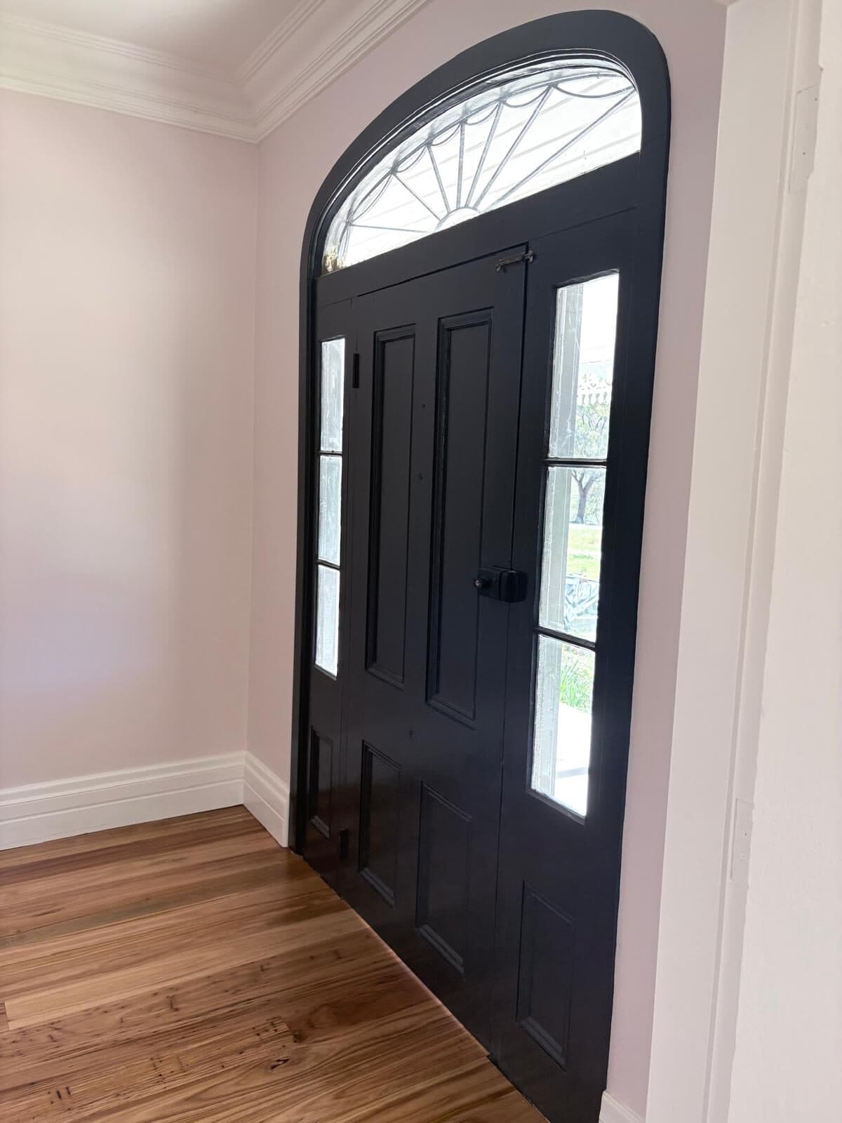 Black painted front door with glazed side panels beneath an arched fanlight, rural homestead east of Orange NSW