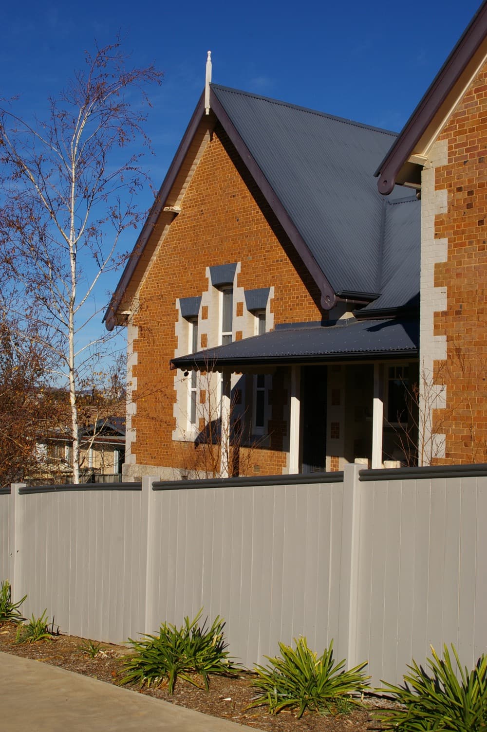 Brick house with painted fence and trim