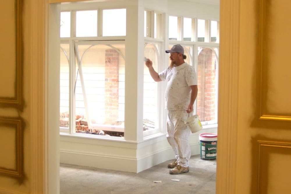 Painter working on conservatory windows