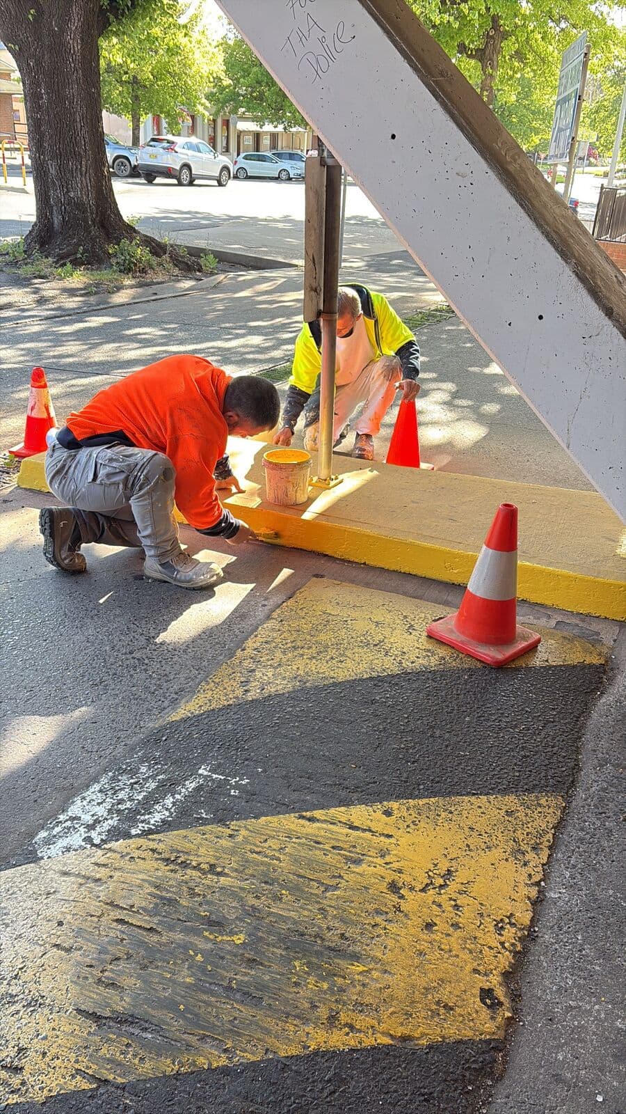 Yellow kerb and safety line marking being repainted in a multi storey shopping centre car park, Orange NSW, work area coned off