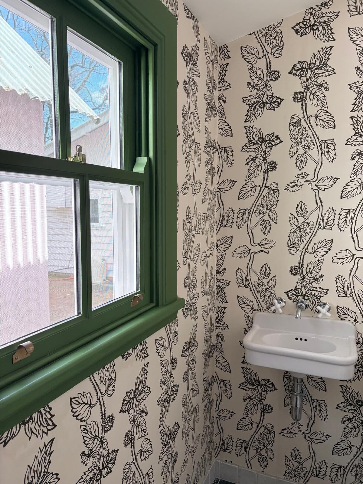 Botanical wallpaper cut in tight around the architrave of a deep green painted double hung sash window in a powder room, Central West NSW
