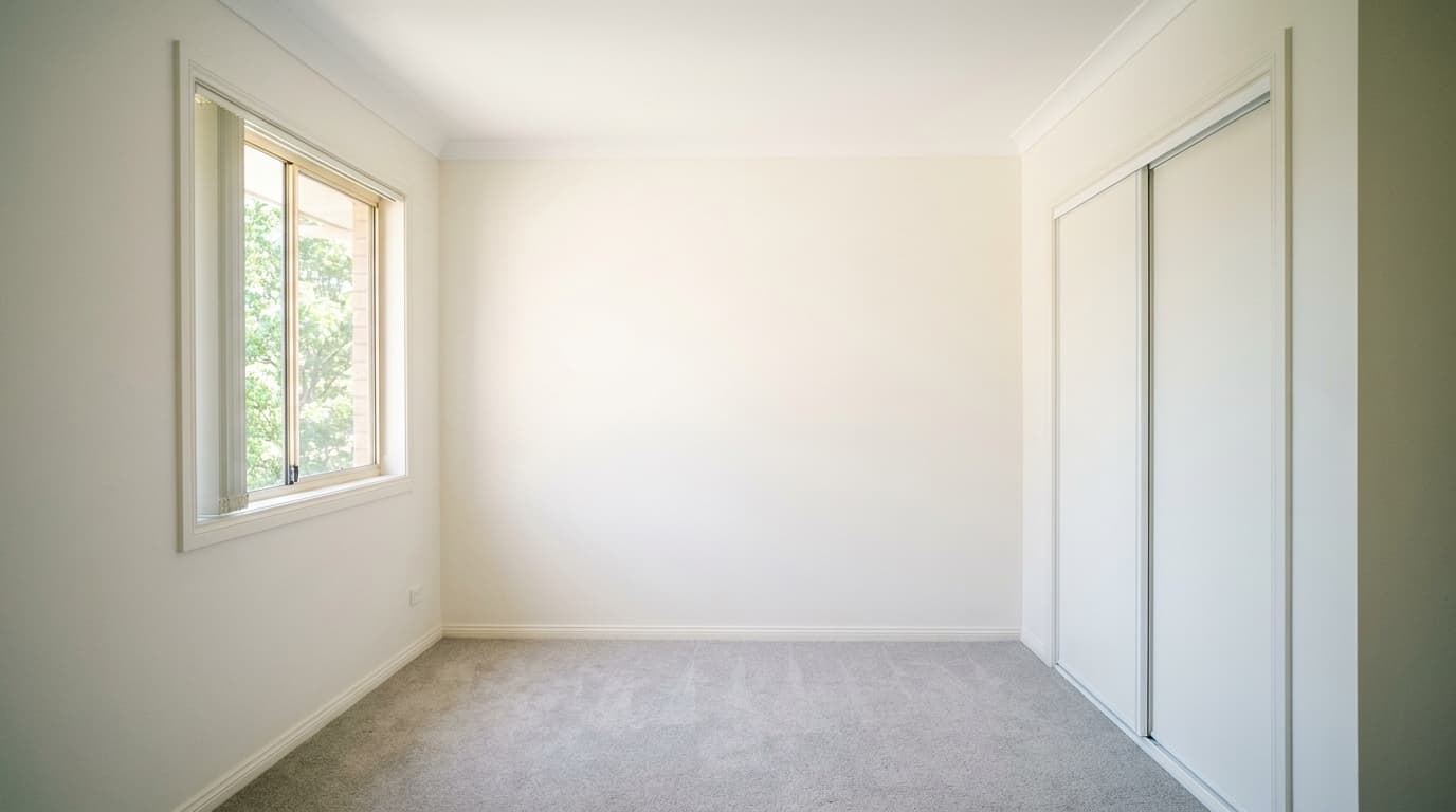 Empty rental bedroom freshly painted in warm white
